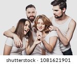 Group of friends playing karaoke over white background. Concept about friendship and people.