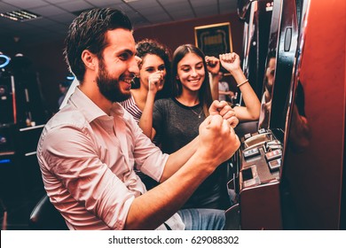 Group Of Friends Playing Slot Machines