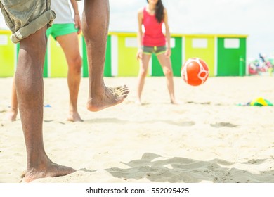 Group of friends playing soccer in copacabana beach game in Brazil - Diverse ethnic people having fun in football match on the sand - Summer vacation concept - Focus on  man feet - Warm filter - Shutterstock ID 552095425