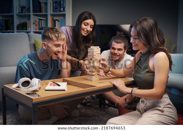 Group of friends playing table games at home,\
they are playing together