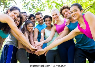Group of friends putting their hands together in the park - Powered by Shutterstock