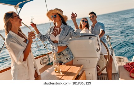 Group of friends relaxing on luxury yacht. Having fun together while sailing in the sea. Traveling and yachting concept.