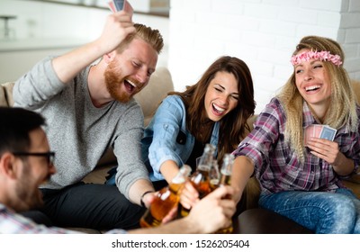 Group Of Friends Relaxing And Playing Cards Together. Young People Hanging Out Together