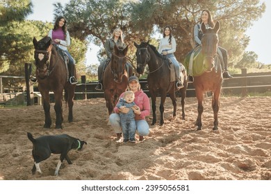 Group of friends riding horses in paddock - Shutterstock ID 2395056581