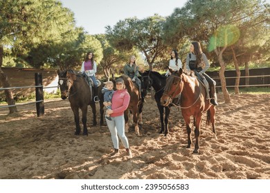 Group of friends riding horses in paddock - Shutterstock ID 2395056583