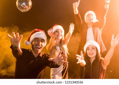 group of friends in santa hats celebrating new year under yellow light - Shutterstock ID 1231340536