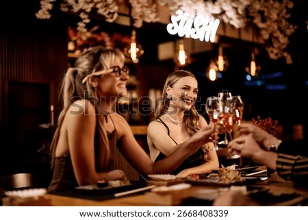 Group of friends sharing dinner, conversation, and drinks in a stylish ambiance