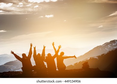 Group of friends sits on the top of mountain and having fun on mountains backdrop  - Shutterstock ID 449134906