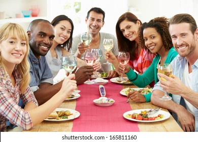 Group Of Friends Sitting Around Table Having Dinner Party