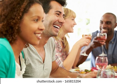 Group Of Friends Sitting Around Table Having Dinner Party