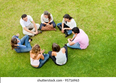 Group Of Friends Sitting Down In A Circle Outdoors