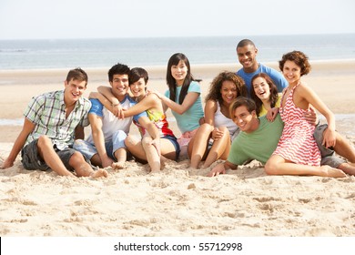 Group Of Friends Sitting On Beach Together