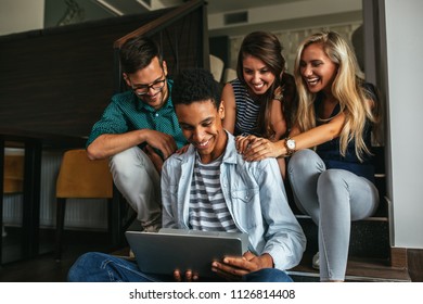 Group Of Friends Sitting And Watching Something On A Laptop Computer