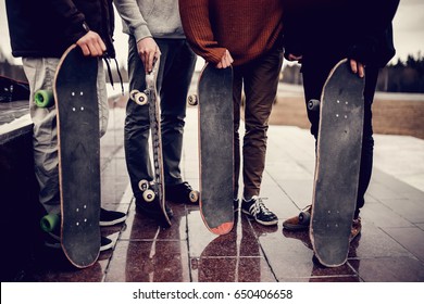 Group of friends skateboarders go in for sports on the street and ride skateboards, shoes in holes and abrasions. The concept is to lead the team to victory. Monochrome and high contrast. - Powered by Shutterstock