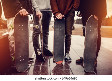 Group of friends skateboarders rest on the street and skateboard, shoes in holes and scuffs. Concept street hooligans. Monochrome and high contrast. - Powered by Shutterstock