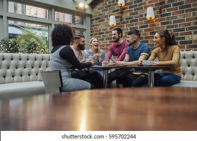 Group Of Friends Are Socialising Over Coffee In A Bar/restaurant. 