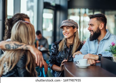 Group of friends are socializing and drinking coffee while sitting together at cafe - Powered by Shutterstock