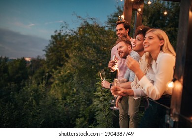 Group of friends socializing at the terrace and having drinks