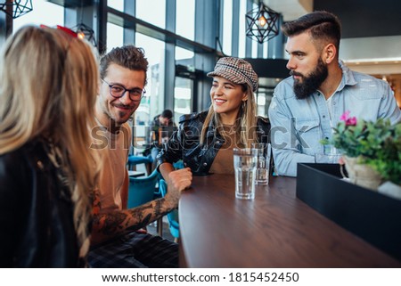 Group of friends are socializing while sitting together at cafe