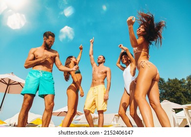 Group of friends in swimsuit dance music in a swimming pool - Powered by Shutterstock