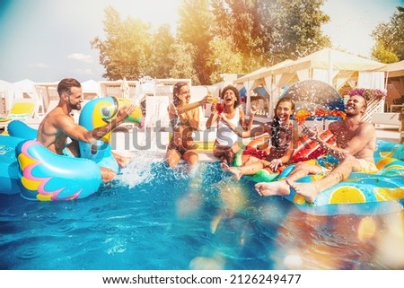 Group of friends in swimsuit enjoy in a swimming pool