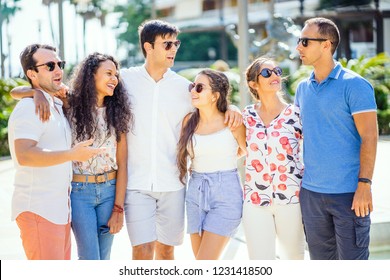 Group of friends talking and laughing during sunny day in the city