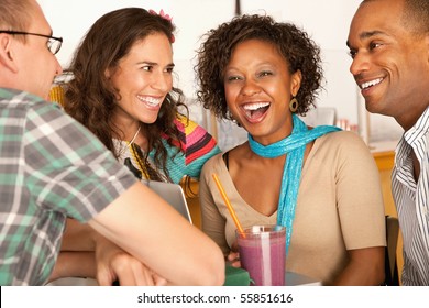 A group of friends are talking and smiling with each other.  One woman is looking towards the camera.  Horizontal shot. - Powered by Shutterstock