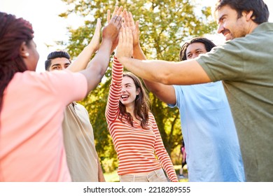 Group of friends as a team in nature at the high five for team building and motivation - Shutterstock ID 2218289555
