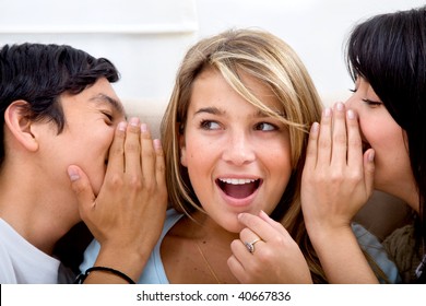 Group of friends telling a secret at home