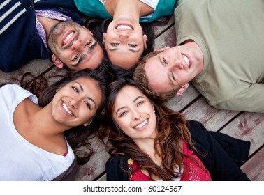 Group Of Friends With Their Heads Together In A Circle Outdoors