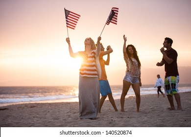 Group of Friends in their twenties dancing on the Beach at Sunset on 4th of July - Powered by Shutterstock