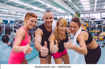 Group of friends with thumbs up smiling on a fitness center after hard training day - Powered by Shutterstock