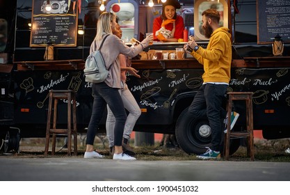 Group Of Friends Toasting And Eating In Front Of Modified Truck For Mobile Fast Food Service