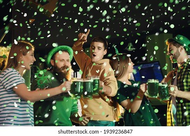 Group of friends toasting with green beer in pub. St. Patrick's Day celebration - Powered by Shutterstock
