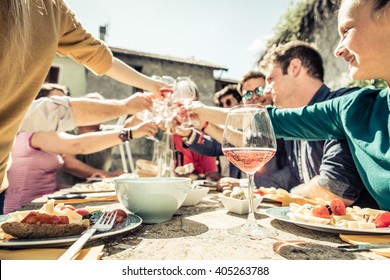 Group of friends toasting wine glasses and having fun outdoors - People having lunch in a restaurant