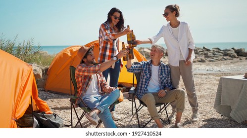 Gruppenfreunde zusammen im Urlaub Bier trinken und Spaß am Strand im Camping haben. Freundschafts- und Feierlichkeiten.