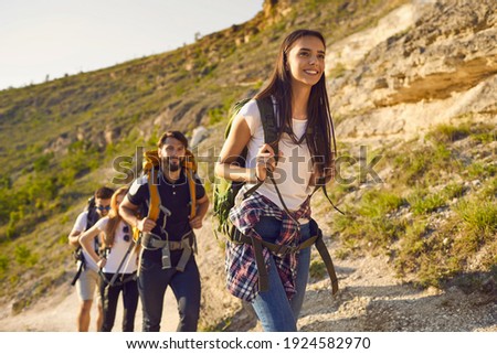 Group of friends tourists with backpacks traveler in the mountains on a hike hiking along the route in nature in summer. Outdoor activities adventure for people.