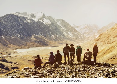 Group Of Friends Or Tourists Stands At Mountains Viewpoint. Travel Or Tourism Concept