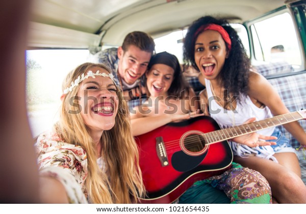 Group of friends travelling with a vintage
minivan - Hippies driving into the
nature