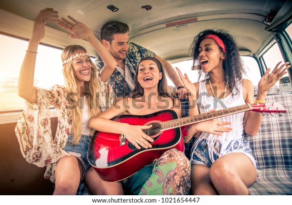 Group of friends travelling with a vintage\
minivan - Hippies driving into the\
nature
