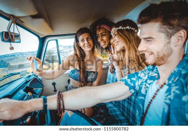 Group of friends travelling with a vintage
minivan - Hippies driving into the
nature