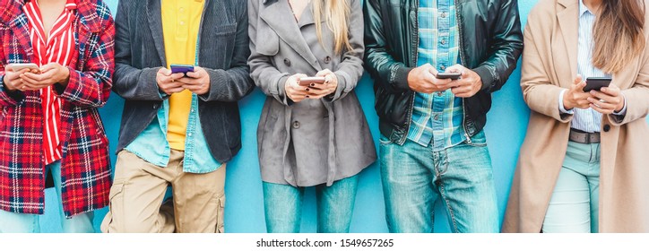 Group of friends using smart mobile phones app - Teenagers addiction to new technology trends - Concept of youth, tech, social and friendship - Focus on center hands 