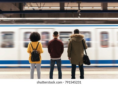 Gruppe von Freunden wartet den Zug in der Plattform der U-Bahn-Station. Konzept des öffentlichen Verkehrs.