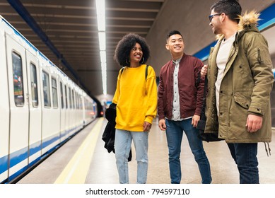 Group Of Friends Waiting The Train In The Platform Of Subway Station. Public Transport Concept.