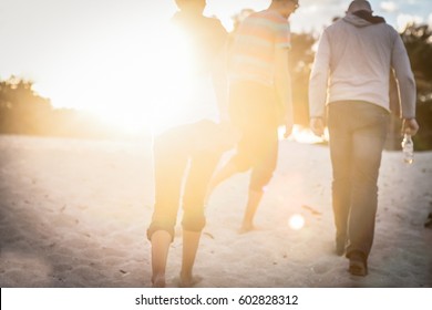 Group Of Friends Are Walking Away From The Beach