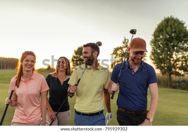 Group of friends\
walking on the golf\
course