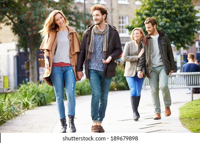 Group Of Friends Walking Through City Park Together