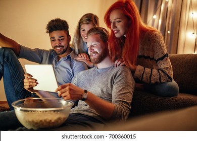 Group Of Friends Watching Favorite TV Show On Tablet.