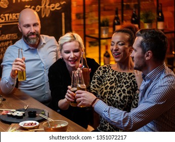 Group Of Friends Watching Tv In A Cafe Behind Bar Counter