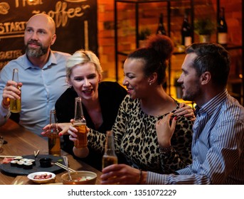 Group Of Friends Watching Tv In A Cafe Behind Bar Counter